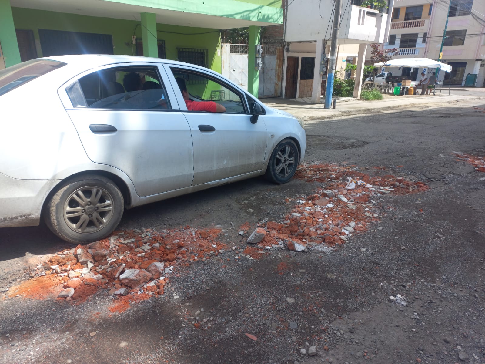 Con ladrillos los moradores de la calle 17 han rellenado los baches de la vía.