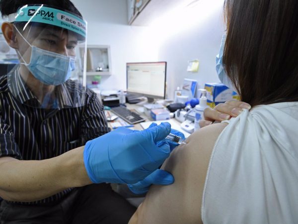 Un doctor inocula la vacuna china Sinovac contra el coronavirus en un centro médico de Singapur.