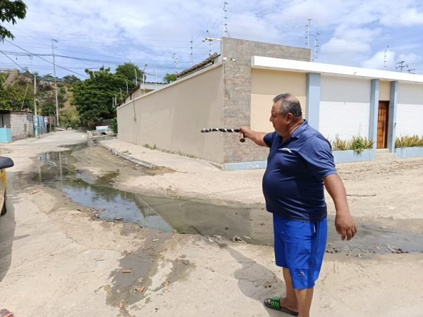 Ángel Espinoza, residente de la zona baja, muestra el recorrido de las aguas negras en el barrio.