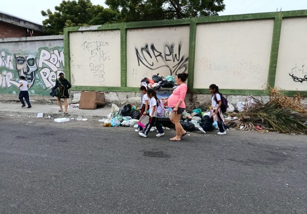 Madres de familia y alumnos esquivan la basura al entrar y salir de sus planteles educativos. Malestar se presenta en la calle 18A.