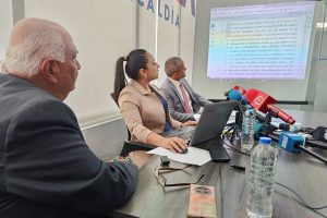 Funcionarios del Registro de la Propiedad mostrando los documentos del bien inmueble durante la rueda de prensa.