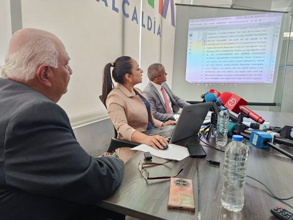 Funcionarios del Registro de la Propiedad mostrando los documentos del bien inmueble durante la rueda de prensa.