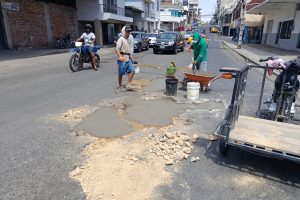 Carlos Hernández junto a Josué Mieles y Javier Basurto mientras tapaban los baches en la calle 14 y avenida 7 en el centro de Manta.
