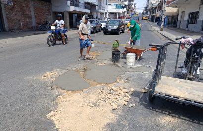 Carlos Hernández junto a Josué Mieles y Javier Basurto mientras tapaban los baches en la calle 14 y avenida 7 en el centro de Manta.