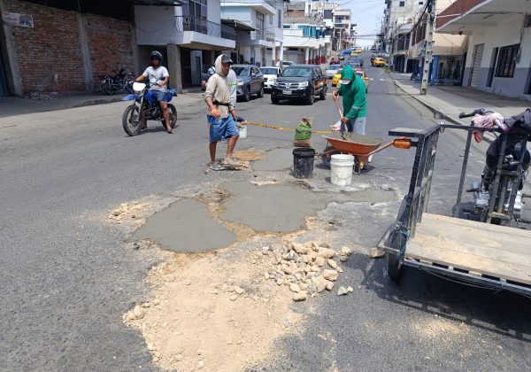 Carlos Hernández junto a Josué Mieles y Javier Basurto mientras tapaban los baches en la calle 14 y avenida 7 en el centro de Manta.