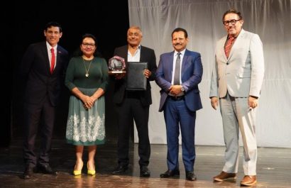 El actor manabita Carlos Valencia recibiendo el reconocimiento de parte de las autoridades de la Uleam.