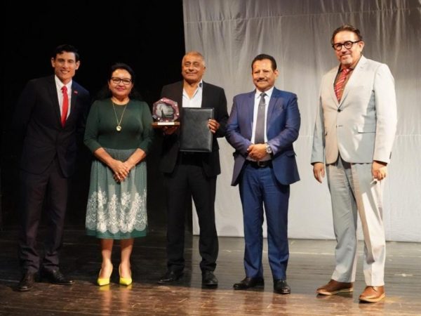 El actor manabita Carlos Valencia recibiendo el reconocimiento de parte de las autoridades de la Uleam.