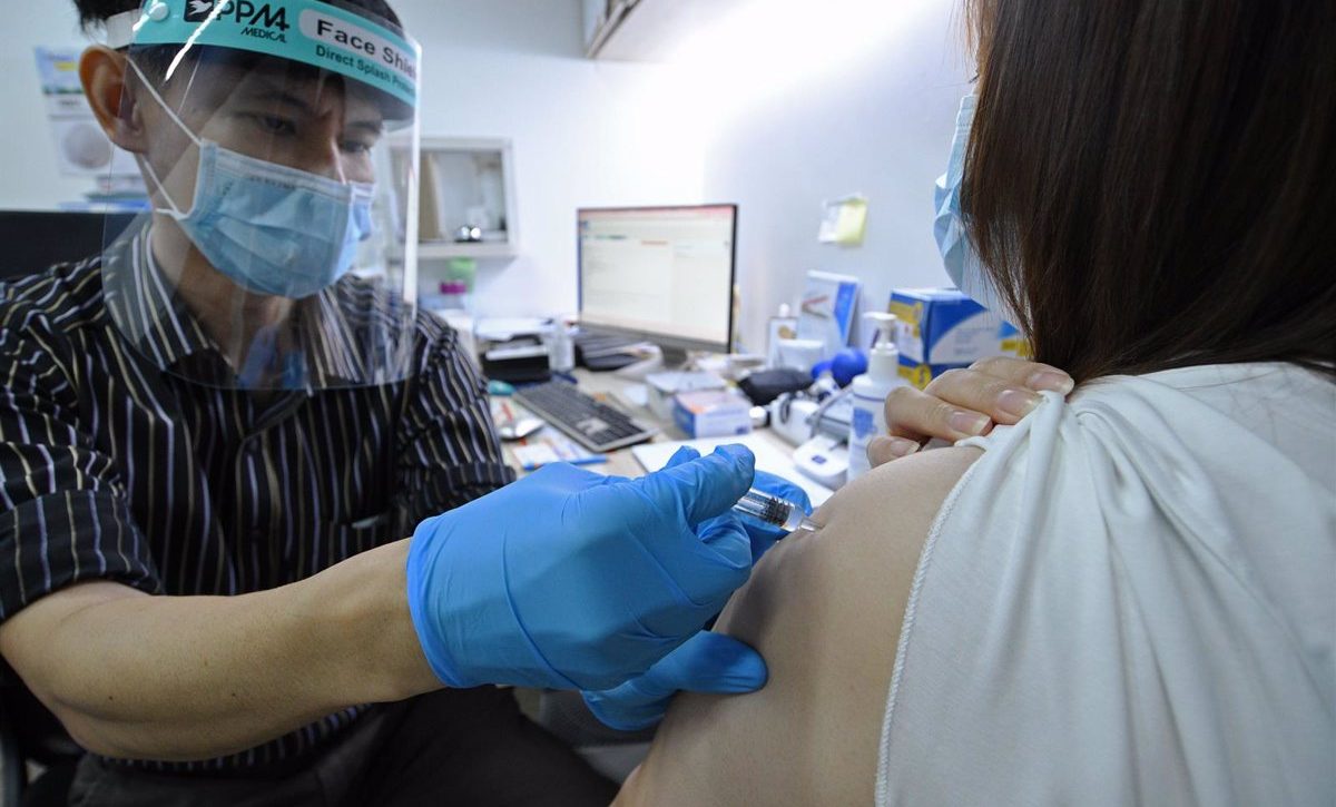 Un doctor inocula la vacuna china Sinovac contra el coronavirus en un centro médico de Singapur.