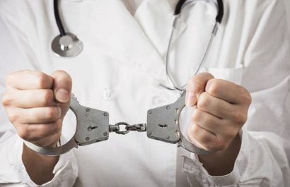 Handcuffed doctor, close-up. Medical malpractice and error concept