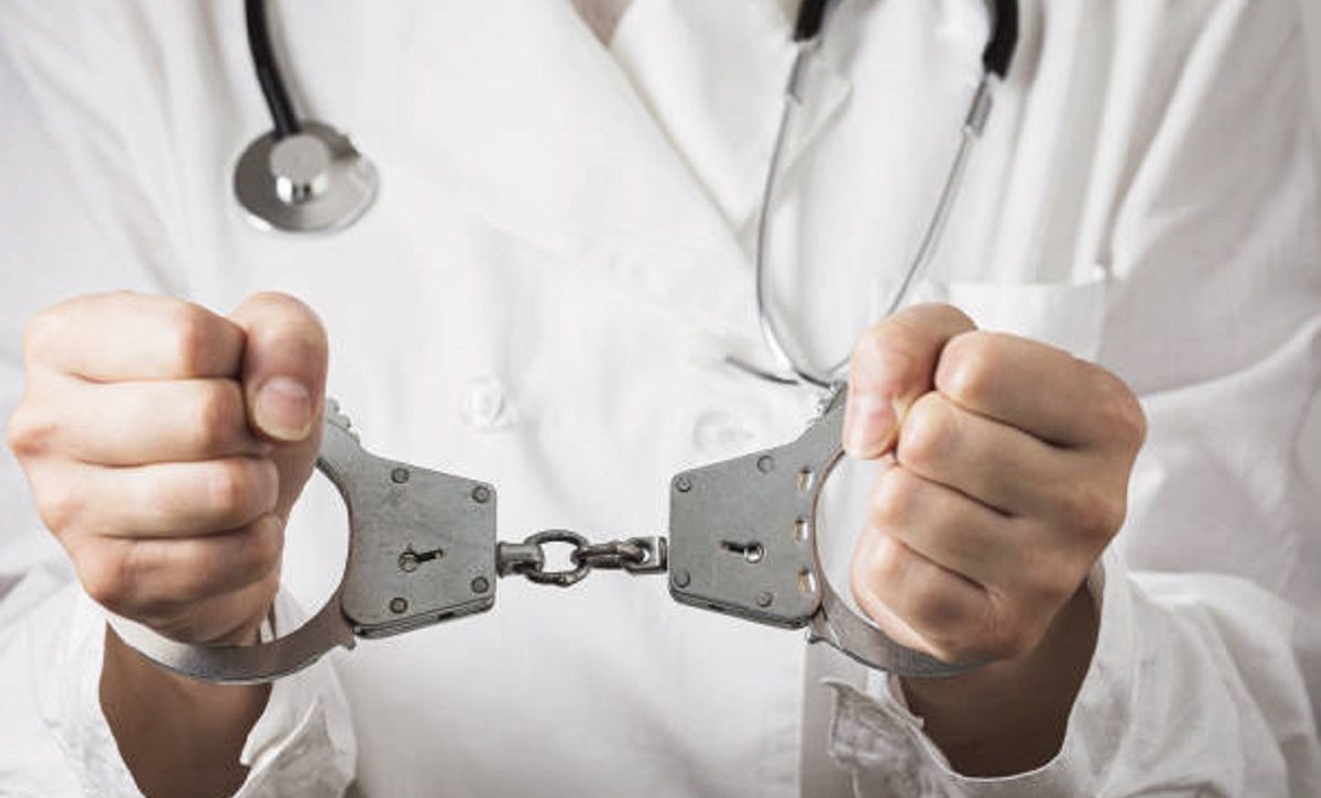 Handcuffed doctor, close-up. Medical malpractice and error concept