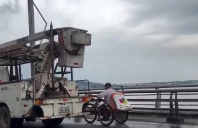 hombre-cruza-puente-prendido-de-un-carro