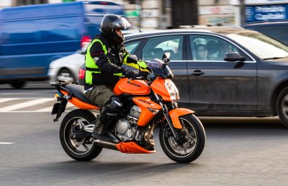 Commuters and office workers on motorcycle during rush hour traffic.  Traffic in downtown Bucharest, Romania, 2020