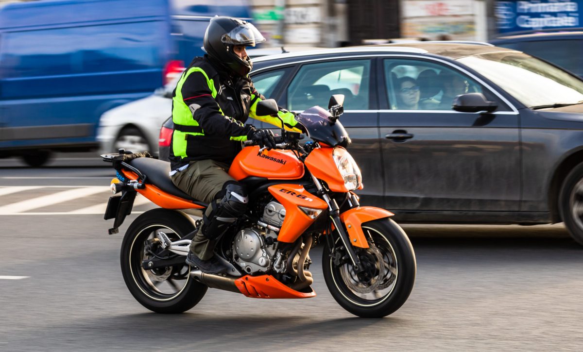 Commuters and office workers on motorcycle during rush hour traffic.  Traffic in downtown Bucharest, Romania, 2020