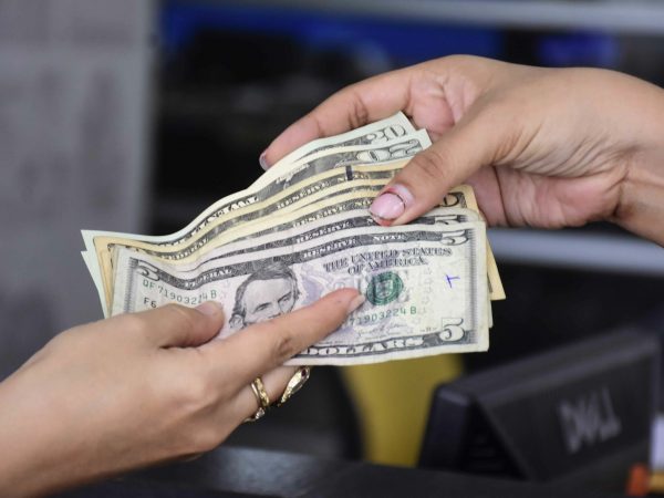 Imagen referencial que muestra el pago en efectivo por un servicio en el Ecuador