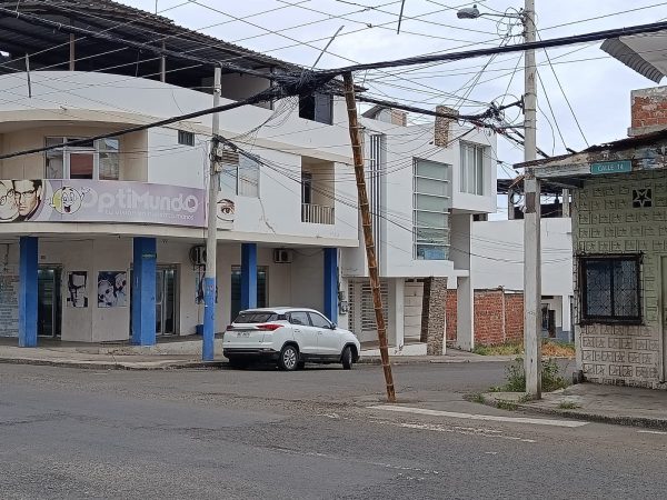 Una caña improvisada sostiene cables de telecomunicaciones en la calle 14 y avenida 14, en Manta.
