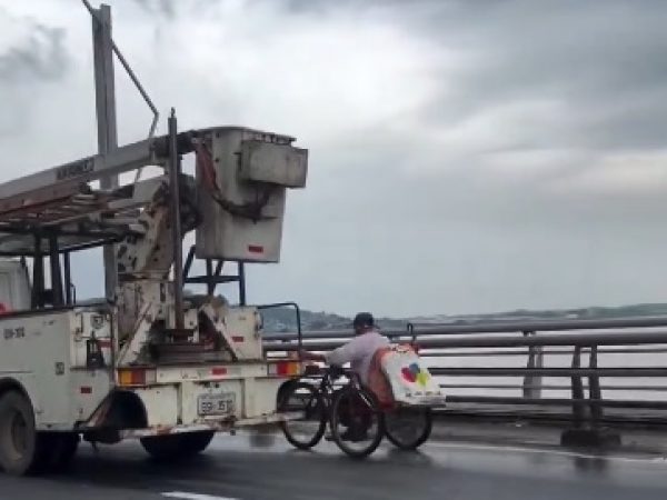 hombre-cruza-puente-prendido-de-un-carro
