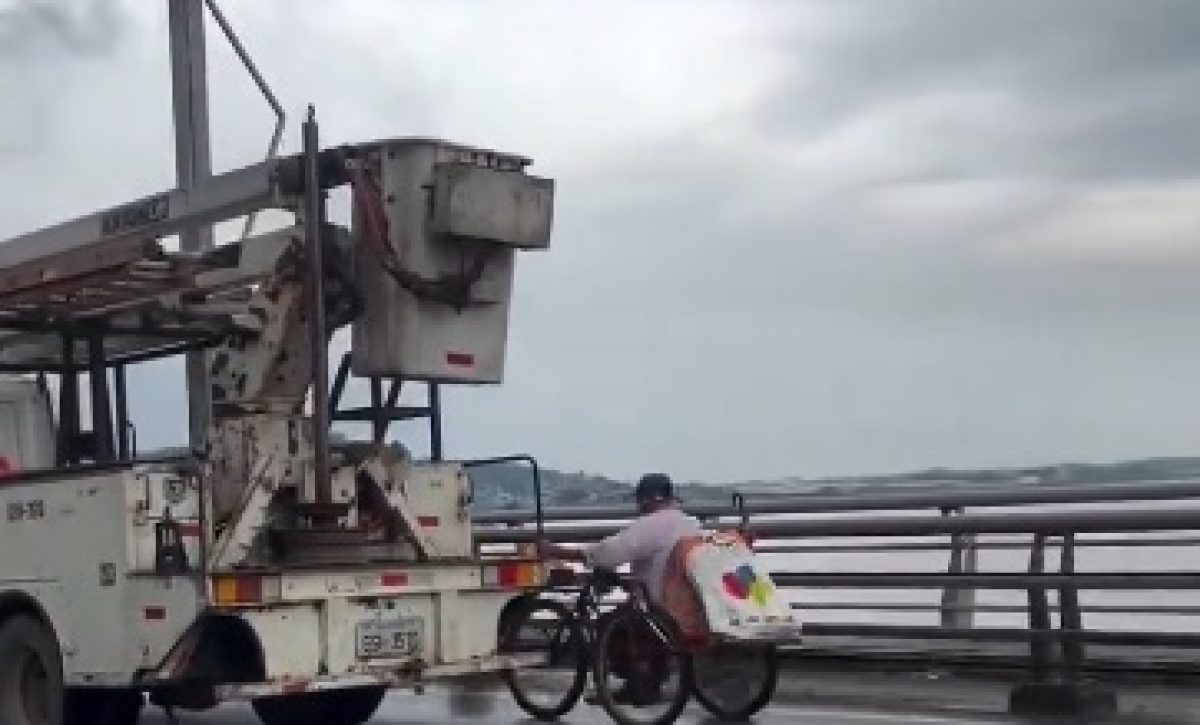 hombre-cruza-puente-prendido-de-un-carro