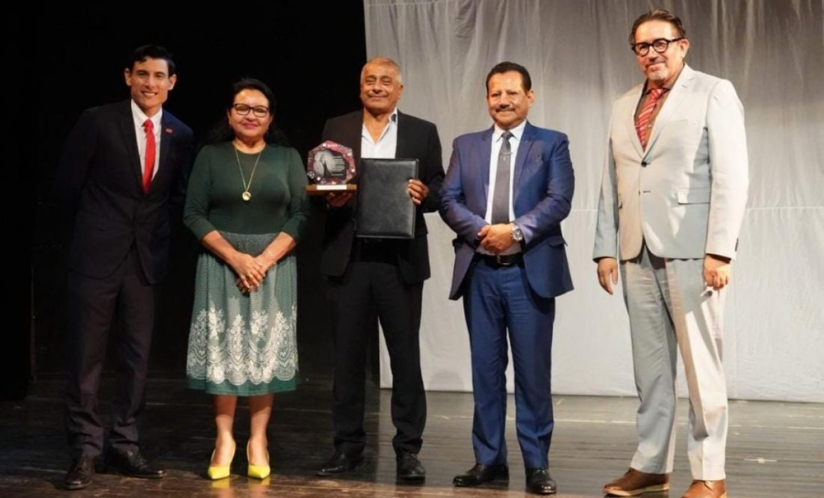El actor manabita Carlos Valencia recibiendo el reconocimiento de parte de las autoridades de la Uleam.