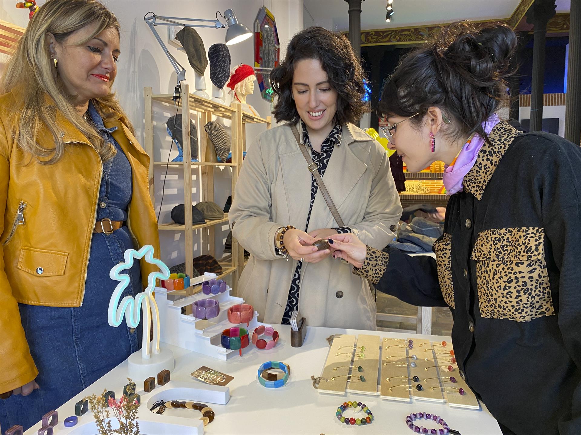 Milena Zavala (c) muestra algunas de las piezas artesanales de tagua que vende en Madrid