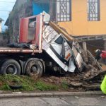 El chofer de un tráiler y su acompañante perdieron la vida luego que este vehículo se impactara contra una vivienda.
