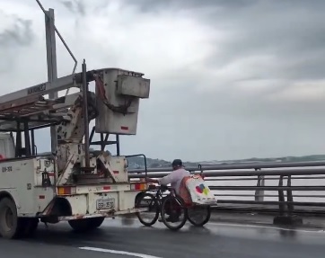 Insólito. Un hombre en silla de ruedas se agarra de camión para cruzar el Puente de la Unidad Nacional en Guayaquil.