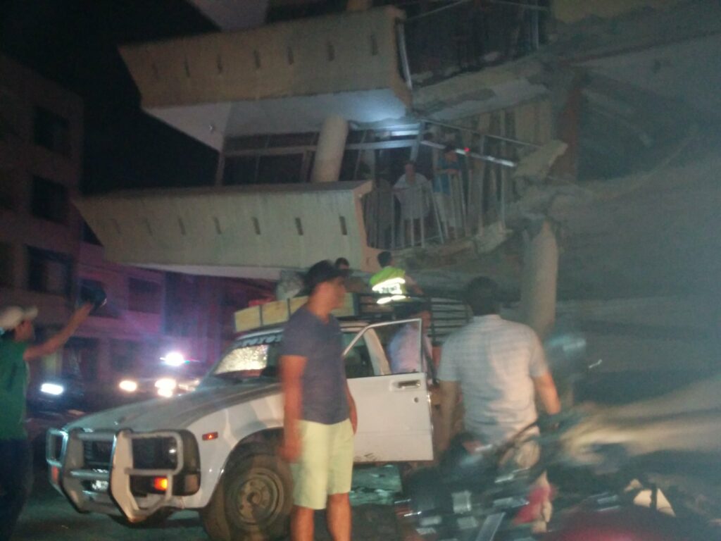 Policías y voluntarios intentan rescatar a una familia de una casa destruida en Portoviejo, la noche del 16 de abril de 2016.