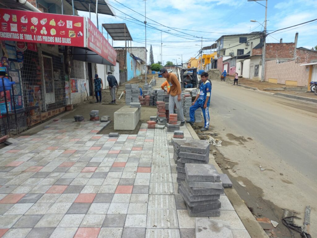 Obreros trabajando en la instalación de adoquines en la calle 321 de la parroquia Eloy Alfaro.