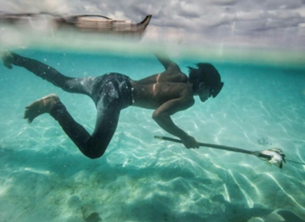 Un joven Bajau pesca peces coralinos y conchas en la isla Mantabuan.