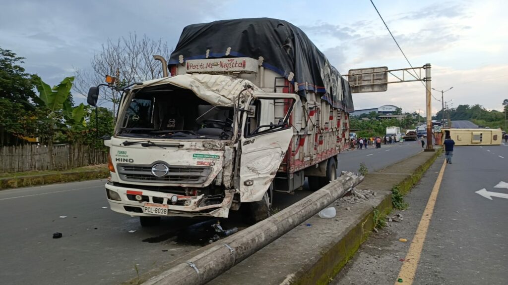 Choques frecuentes y sin respuestas La comunidad de El Carmen, ubicada en la provincia de Manabí, vive una constante preocupación por los accidentes viales que se registran, casi a diario, en el paso lateral, especialmente en los kilómetros 4, 6 y 7. El último incidente no dejó víctimas mortales, pero sí daños materiales significativos y congestionamiento vehicular. Testigos del hecho confirmaron que el bus de transporte interprovincial, que cubre la ruta hacia Santo Domingo, fue impactado por un camión cuando intentaba girar en U. La colisión dejó en evidencia, una vez más, la complejidad y el riesgo de ese tipo de maniobras, que son habituales para los buses que deben incorporarse a la avenida principal. Ciudadanos piden rediseño vial urgente Luis Pusay, dirigente de la cooperativa Rutas Carmenses, responsabilizó a la actual ordenanza municipal que obliga a los buses a utilizar el paso lateral para salir del terminal terrestre. Pusay sugirió que la ruta más segura sería por la calle 3 de Julio, lo que evitaría giros peligrosos en tramos de alto tráfico. Vecinos como Jhonny Basurto relatan que los accidentes son tan frecuentes que han perdido la cuenta. “Aquí hay choques todos los días, unos leves y otros graves. Necesitamos redondeles o muros reductores ya”, declaró. Por su parte, Luciano Marquínez, otro habitante del sector, recordó que hace ocho años realizaron un plantón para exigir la construcción de tres redondeles en los puntos críticos, sin obtener respuesta. “Muchos conductores desconocen los riesgos del giro en U aquí, especialmente los choferes foráneos”, indicó. Infraestructura obsoleta y alta circulación El paso lateral de El Carmen, inaugurado en el año 2012, tiene una longitud de 12 kilómetros, cuenta con cuatro carriles y una ciclovía, y fue construido con la intención de descongestionar el tráfico urbano. Sin embargo, la alta circulación de vehículos pesados y la falta de infraestructura adecuada para los giros han convertido este tramo en una zona de riesgo constante. Según cifras del Servicio Integrado de Seguridad ECU 911, en lo que va del año se han registrado al menos 25 siniestros en ese tramo, principalmente en los puntos donde confluyen vías rurales como San Luis de Cajones, La Esperanza y Venado. Las autoridades locales no han emitido un pronunciamiento oficial sobre posibles reformas o intervenciones viales tras este nuevo incidente. Sin embargo, desde distintos sectores sociales y de transporte se exige que el Municipio de El Carmen revise la normativa y ejecute obras que reduzcan el riesgo para choferes y pasajeros.