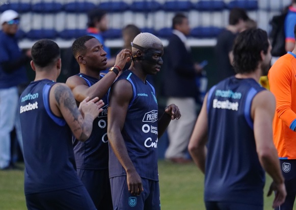 Pervis Estupiñán le coloca la máscara protectora a Moisés Caicedo durante la práctica de la selección de Ecuador