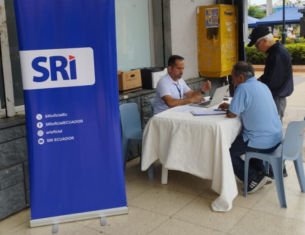 Un funcionario del SRI brindando información a un adulto mayor. FOTO: @SRIoficialEc