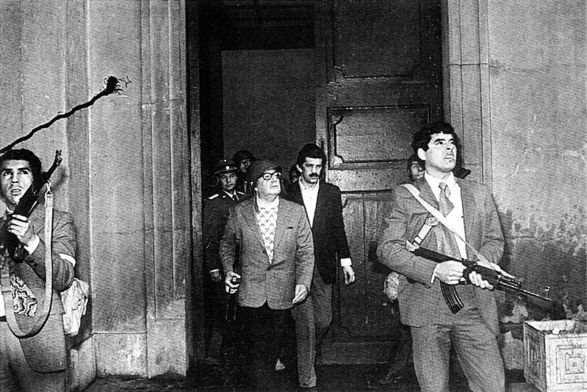 El presidente Salvador Allende, con un casco, junto a guardaespaldas mientras las fuerzas de Augusto Pinochet continuaban su asedio armado contra el palacio presidencial. (Reuters).