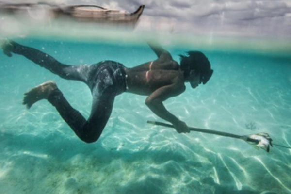 Un joven Bajau pesca peces coralinos y conchas en la isla Mantabuan.