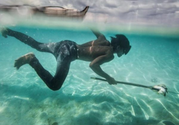 Un joven Bajau pesca peces coralinos y conchas en la isla Mantabuan.
