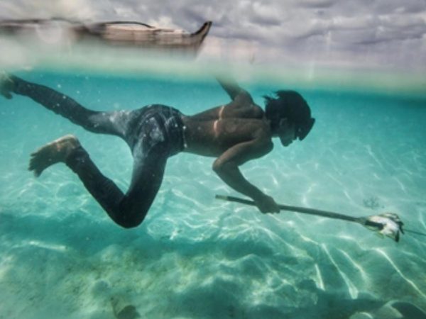 Un joven Bajau pesca peces coralinos y conchas en la isla Mantabuan.