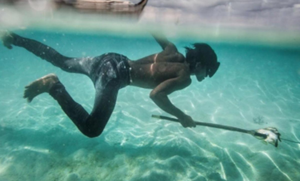 Un joven Bajau pesca peces coralinos y conchas en la isla Mantabuan.