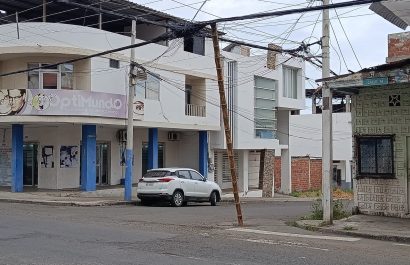 Una caña improvisada sostiene cables de telecomunicaciones en la calle 14 y avenida 14, en Manta.