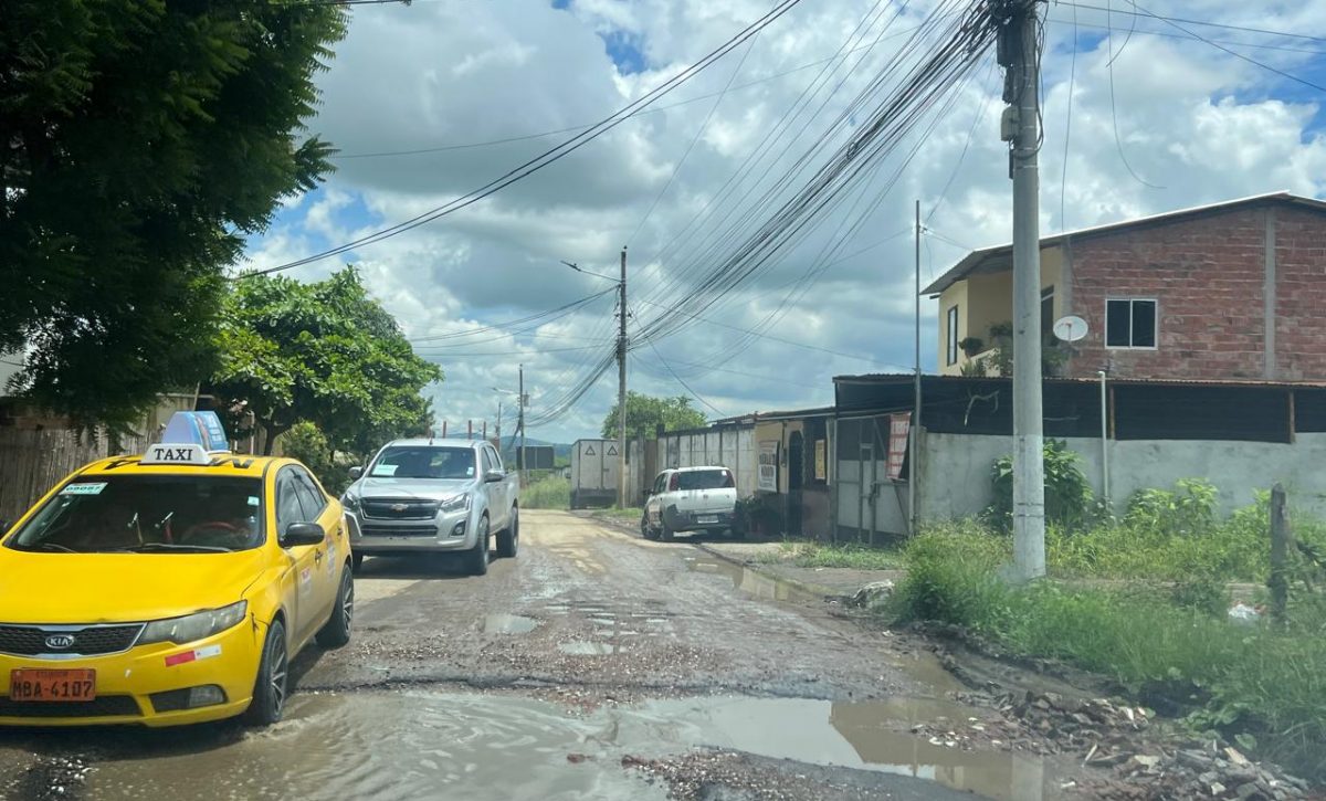 Los vehículos deben sortear los baches que hay en la calle principal de esta ciudadela.