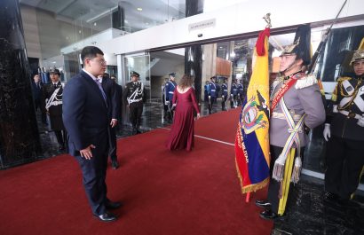 Dominique Serrano asambleísta de Ecuador saludando la Bandera