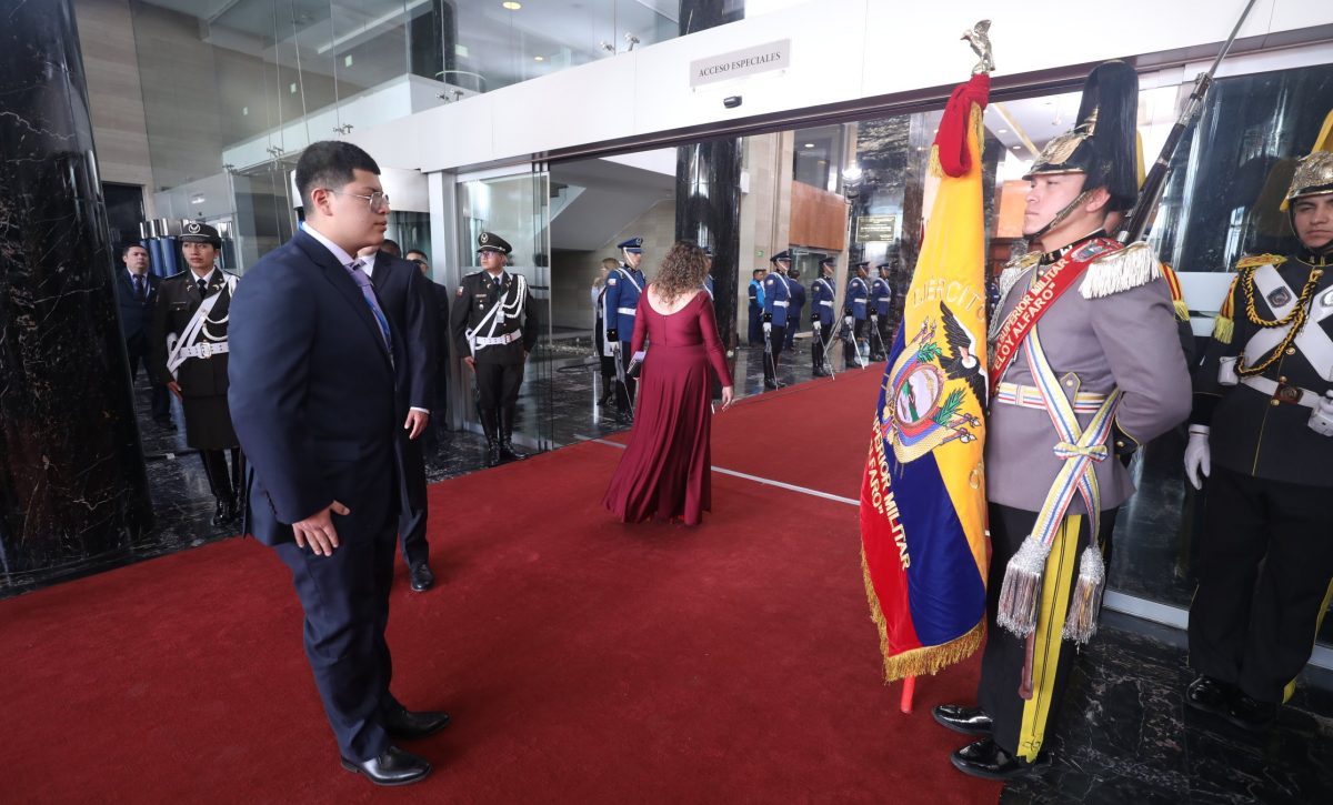 Dominique Serrano asambleísta de Ecuador saludando la Bandera