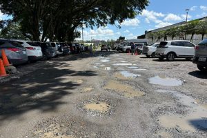 Huecos profundos, lodo y agua estancada deterioran la calle Río Tanti, vía clave del centro de Santo Domingo.
