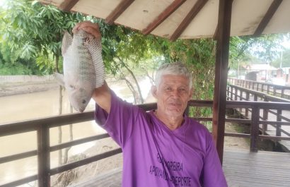 Wilfrido Acosta, conocido como "Chino Domo", muestra la pesca de una tilapia.