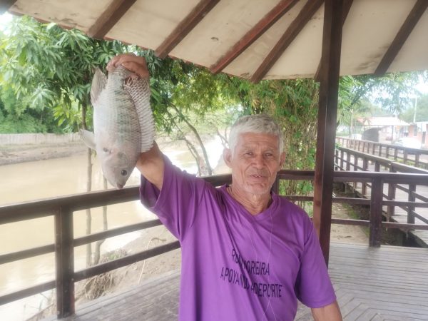 Wilfrido Acosta, conocido como "Chino Domo", muestra la pesca de una tilapia.