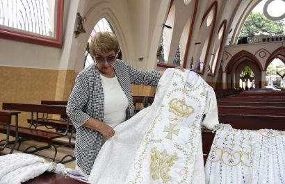 Herlinda Loor muestra uno de los vestidos de la Virgen La Merced, en Portoviejo