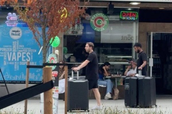 Pedro Vite con maletas en la calle Robson de Vancouver