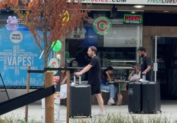 Pedro Vite con maletas en la calle Robson de Vancouver