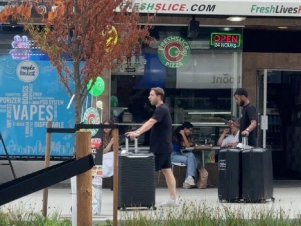 Pedro Vite con maletas en la calle Robson de Vancouver