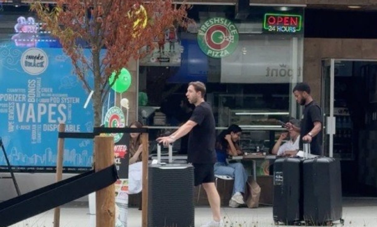 Pedro Vite con maletas en la calle Robson de Vancouver