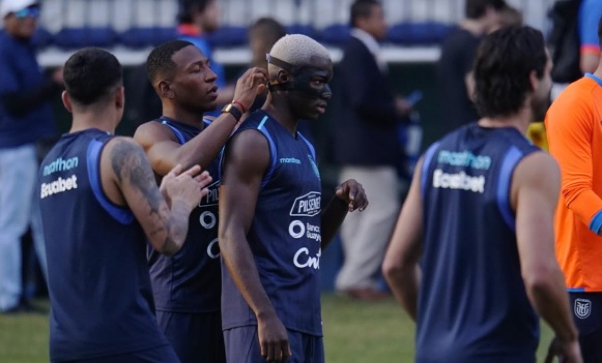 Pervis Estupiñán le coloca la máscara protectora a Moisés Caicedo durante la práctica de la selección de Ecuador