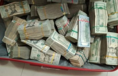 Una maleta llena de fajos de dinero se descubrió en la vivienda de una agente policial en servicio activo durante un allanamiento.
